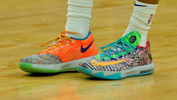 View of orange and green Nike KD shoes.